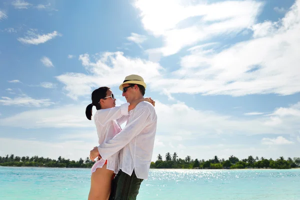 Glada unga par ha kul på stranden — Stockfoto