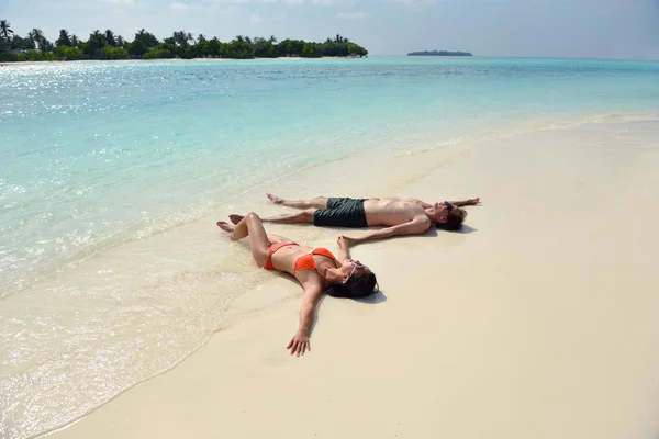 Felice giovane coppia divertirsi sulla spiaggia — Foto Stock