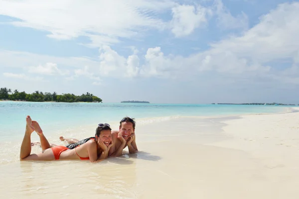 Glada unga par ha kul på stranden — Stockfoto