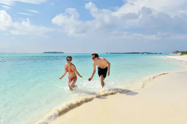 Glada unga par ha kul på stranden — Stockfoto