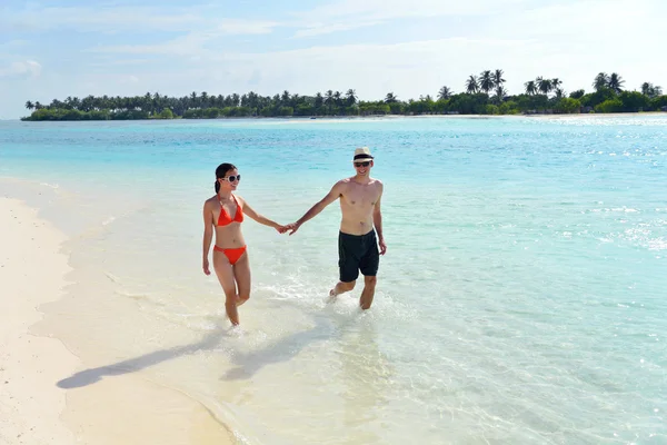 Glada unga par ha kul på stranden — Stockfoto