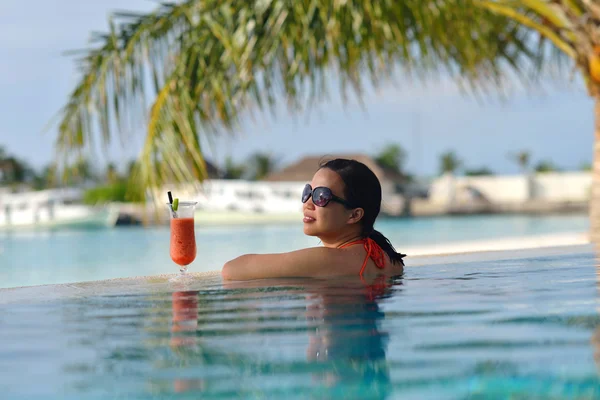 Beautiful young woman with a drink by the sea — Stock Photo, Image