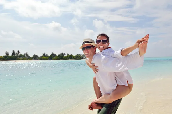 Glückliches junges Paar hat Spaß am Strand — Stockfoto