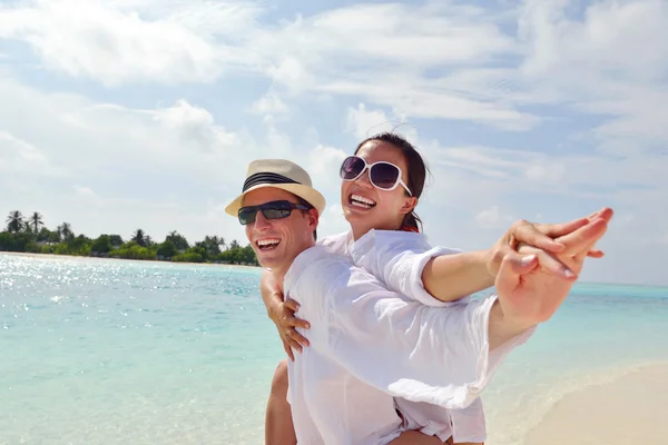 Heureux jeune couple avoir du plaisir sur la plage — Photo