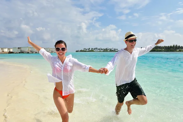 Heureux jeune couple avoir du plaisir sur la plage — Photo