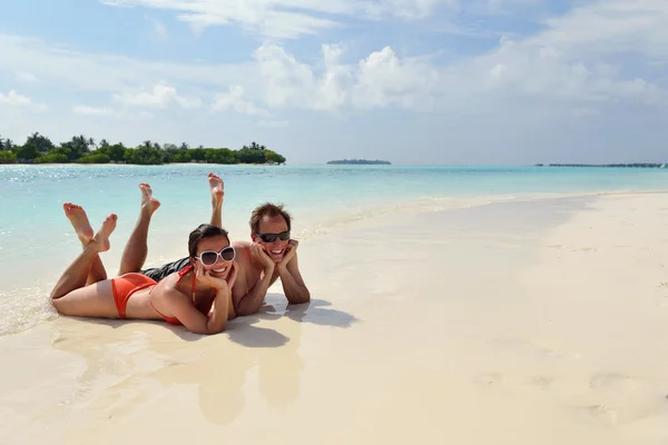 Glada unga par ha kul på stranden — Stockfoto