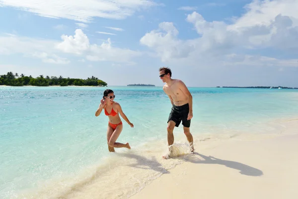 Heureux jeune couple avoir du plaisir sur la plage — Photo