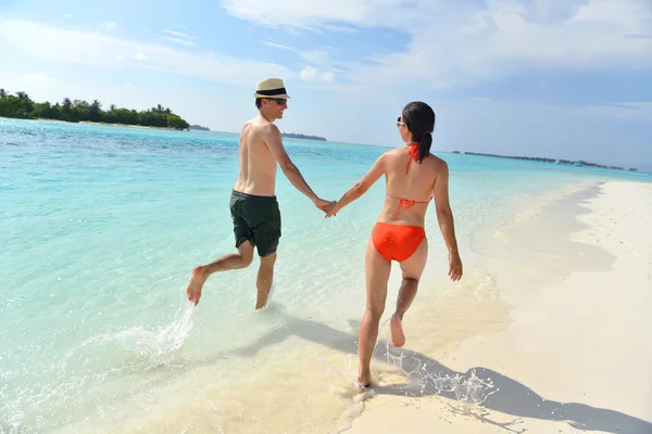 Feliz pareja joven divertirse en la playa — Foto de Stock