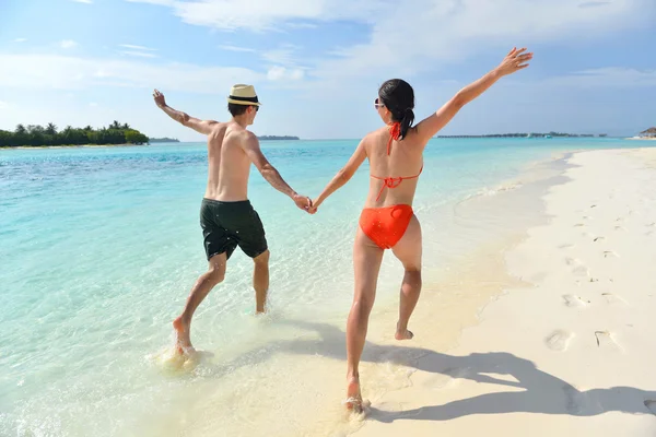 Feliz pareja joven divertirse en la playa — Foto de Stock