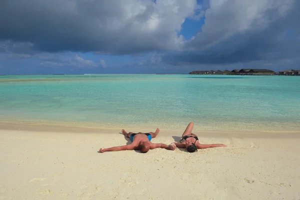 Glada unga par ha kul på stranden — Stockfoto