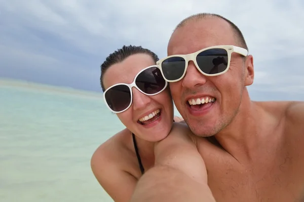 Heureux jeune couple avoir du plaisir sur la plage — Photo