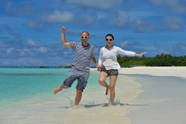 Heureux jeune couple avoir du plaisir sur la plage — Photo