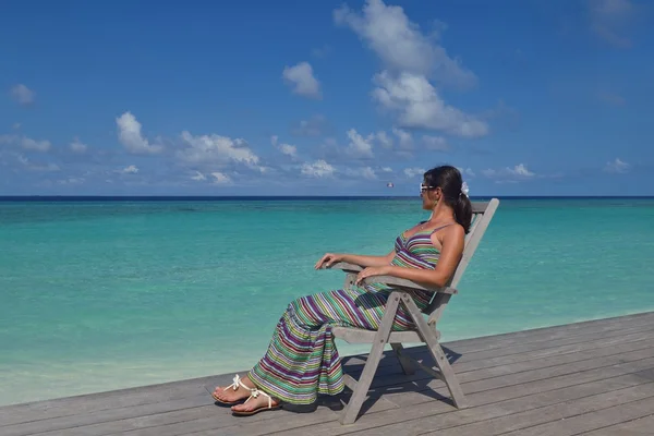 Mooie jonge vrouw met een drankje bij de zee — Stockfoto