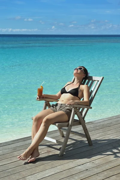 Красива молода жінка з випивкою біля моря — стокове фото
