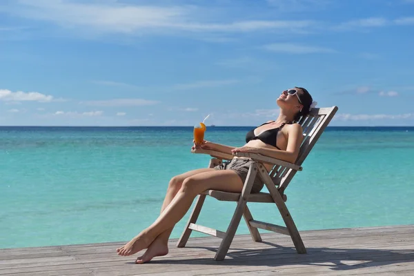 Schöne junge Frau mit einem Drink am Meer — Stockfoto