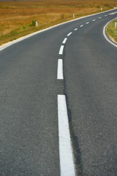 Asphalt road through the field and clouds on blue sky in summer day — Stock Photo, Image