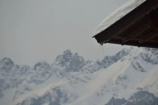 雪に覆われた屋根と美しい山の風景 — ストック写真