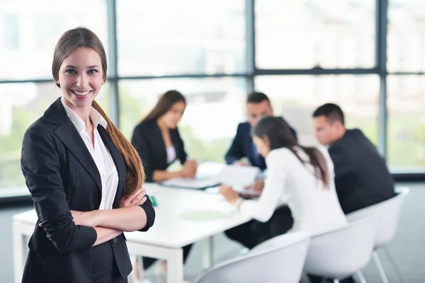 Mujer de negocios con su personal en segundo plano en la oficina — Foto de Stock