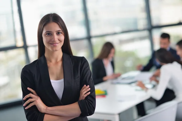 Business woman with her staff in background at office — Stock Photo, Image