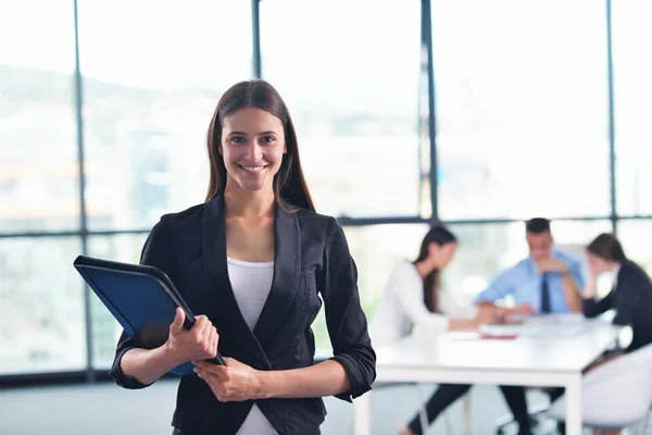 Mujer de negocios con su personal en segundo plano en la oficina — Foto de Stock