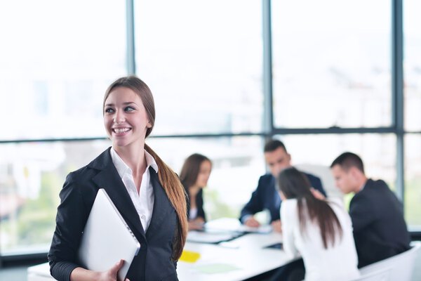 business woman with her staff in background at office