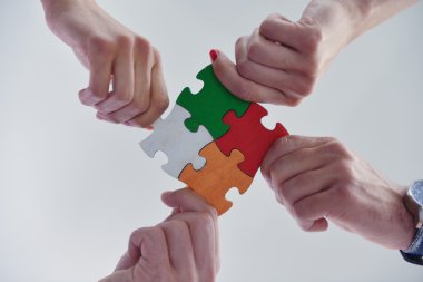 Group of business people assembling jigsaw puzzle clipart