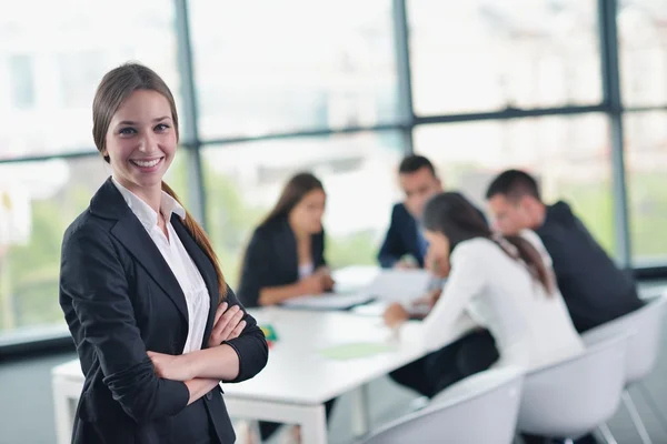 Business woman with her staff in background at office — Stock Photo, Image