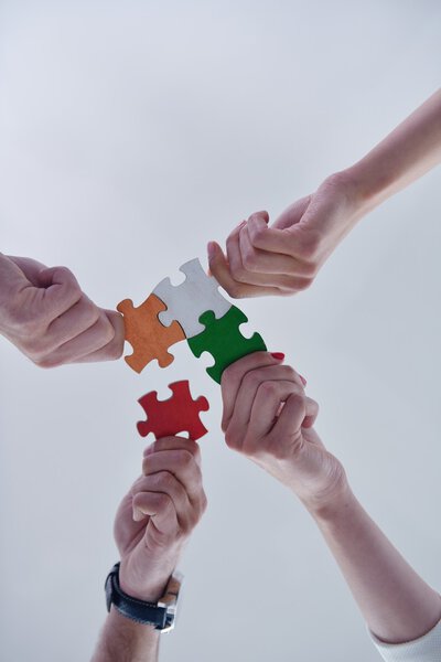 Group of business people assembling jigsaw puzzle