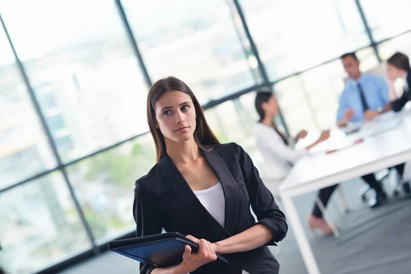 Mujer de negocios con su personal en segundo plano en la oficina — Foto de Stock