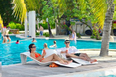 Genç çift rahatla ve taze iç havuz kenarında bakalım