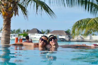 Genç çift rahatla ve taze içecekler havuz kenarında al