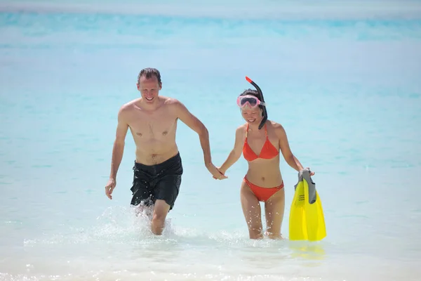 Счастливая молодая пара веселитесь на пляже — стоковое фото