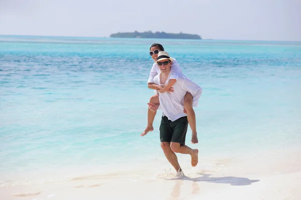 Glada unga par ha kul på stranden — Stockfoto