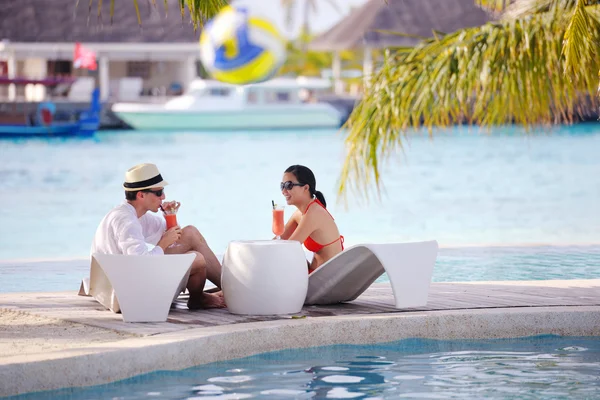 Jovem casal relaxar e tomar bebidas frescas na beira da piscina — Fotografia de Stock