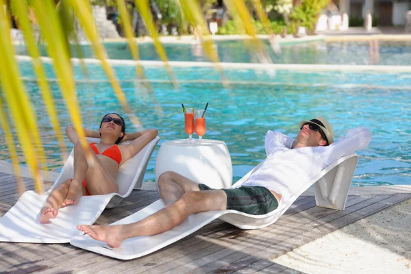 Młoda para zrelaksować się i wziąć świeże drinki przy basenie — Zdjęcie stockowe