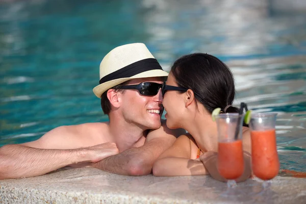 Szczęśliwa młoda para zrelaksować się i wziąć świeże drinki przy basenie — Zdjęcie stockowe