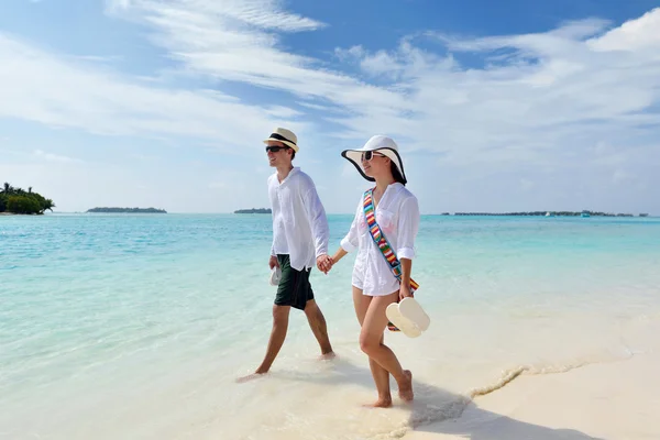 Joyeux jeune couple marchant sur la plage — Photo