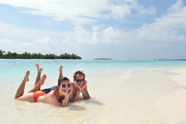 Heureux jeune couple avoir du plaisir sur la plage — Photo