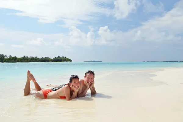 Heureux jeune couple avoir du plaisir sur la plage — Photo