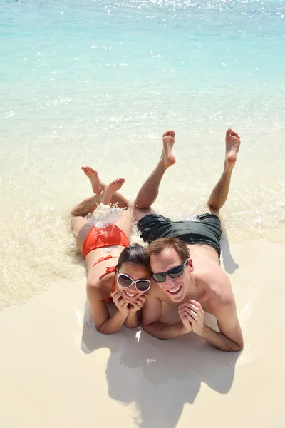 Heureux jeune couple avoir du plaisir sur la plage — Photo