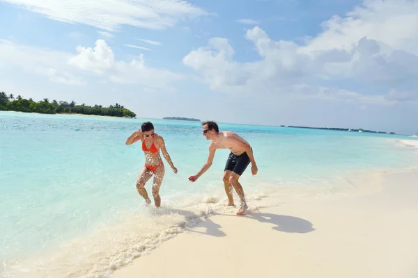 Glückliches junges Paar hat Spaß am Strand — Stockfoto