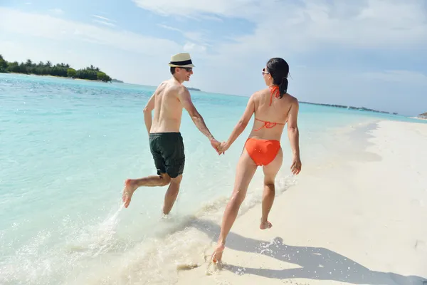 Heureux jeune couple avoir du plaisir sur la plage — Photo