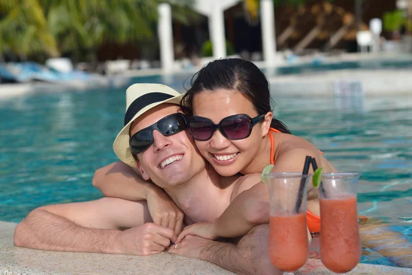 Jovem casal relaxar e tomar bebidas frescas na beira da piscina — Fotografia de Stock