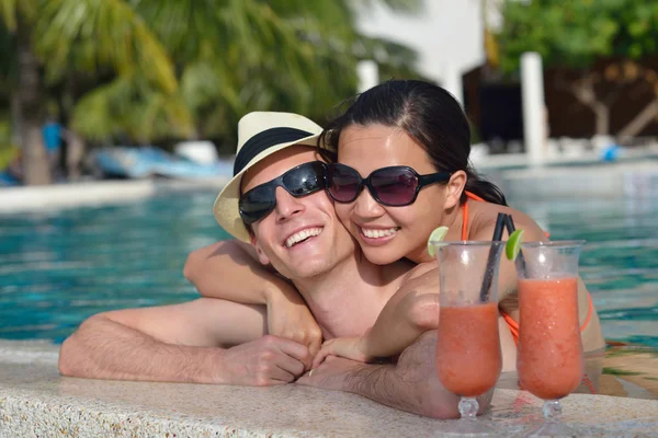 Jovem casal relaxar e tomar bebidas frescas na beira da piscina — Fotografia de Stock