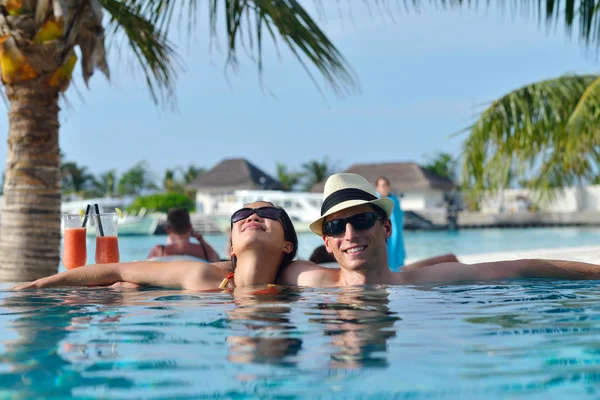 Junges Paar entspannt sich und nimmt frische Getränke am Pool — Stockfoto