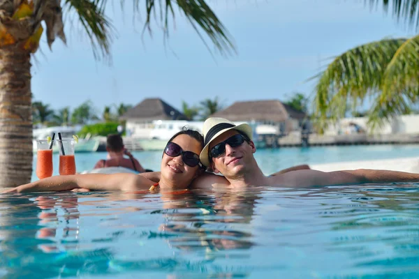 Junges Paar entspannt sich und nimmt frische Getränke am Pool — Stockfoto