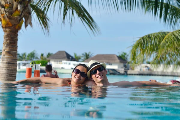 Pareja joven relajarse y tomar bebidas frescas en la piscina —  Fotos de Stock