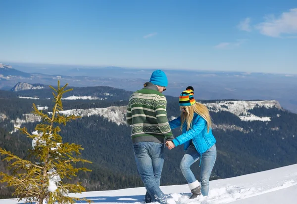 Pareja joven en escena de nieve de invierno — Foto de Stock