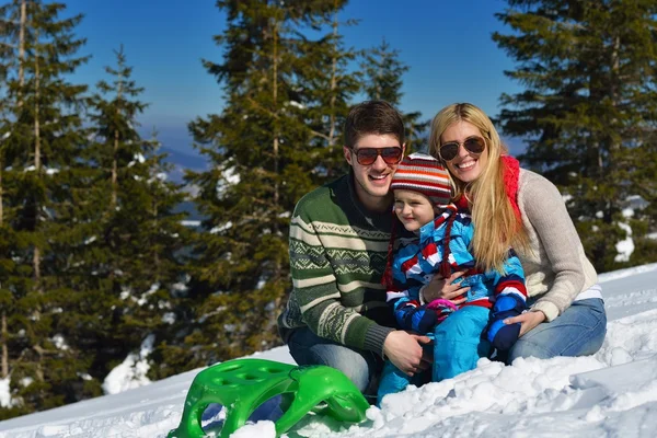 Familie har det sjovt på frisk sne om vinteren ferie - Stock-foto