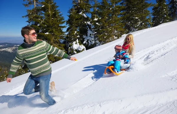 Familjen har kul på nysnö på vintern — Stockfoto